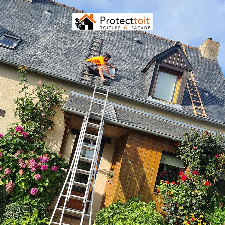 Couvreur Protecttoit au travail sur une toiture en ardoise d'une maison à Saint-Malo